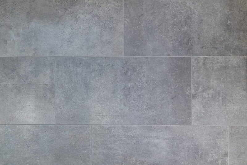 Graue Betonoptik-Fliesen mit natürlicher Textur von RIKKER Haus GmbH.